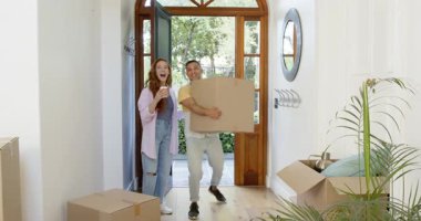 Mutlu adam ve partneri yeni bir eve taşınıyorlar, kutuları yeni bir eve taşıyorlar, aile hayatı, mutluluk, yaşam tarzı ve ilişki konsepti..