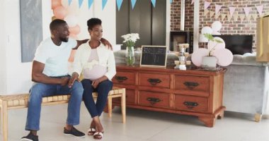 Cinsiyet teşhisi, mutlu siyah çift ve yaşlı ebeveynler bebek partisinde balonlu kutuyu açıyorlar. Kutlama, ebeveynlik, parti ve aile kavramı.