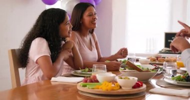 Çeşitli aileler geleneksel törenleri kutluyor, masada oturuyor, yemek yiyor ve evde konuşuyor. Bar mitzvah, bat mitzvah, Aile, ebeveynlik, gelenek ve kutlama konsepti.