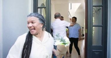 Çeşitli kıdemli arkadaşlar çeşitli çiftlerin evlerine şarap ve çiçeklerle geliyorlar. Kutlama, parti, ev, yaşlılar yaşam tarzı ve arkadaşlık kavramı.