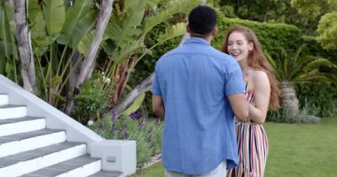 Mutlu adam diz çöküp, yüzük veriyor ve bahçede ortağına evlenme teklif ediyor. Nişan, aşk, mutluluk, yaşam tarzı ve ilişki kavramı.