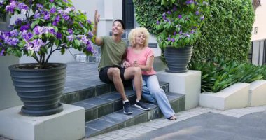 Eşikte oturan, çevreye hayran olan ve yeni eve giren mutlu çift. ev, ilişki, yaşam tarzı ve mülkiyet kavramı.