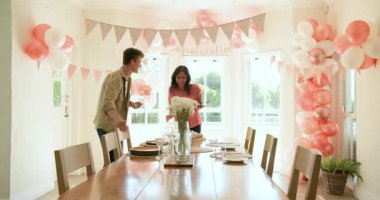 Çeşitli arkadaşlar evde parti için tabak ve dekorasyon hazırlıyorlar ve duvarda tebrik mesajı var. parti, kutlama, arkadaşlık konsepti.