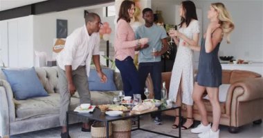 Bir grup mutlu arkadaş oturma odasındaki eve hoş geldin partisinde kucaklaşıyorlar. Kutlama, parti, yaz ve arkadaşlık konsepti.