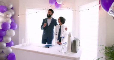 Çeşitli aileler geleneksel tören hazırlıyor ve evde dekorasyonlar ve masada yemekle konuşuyorlar. Bar mitzvah, bat mitzvah, Aile, ebeveynlik, gelenek ve kutlama konsepti.