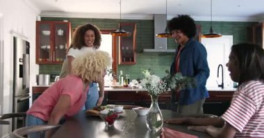 Mutfaktaki masada bira içerken arkadaşlarıyla kadeh tokuşturan mutlu çift. Kutlama, parti, birliktelik, yaşam tarzı ve arkadaşlık kavramı.