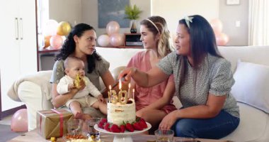 Doğum günü pastasında mum üfleyerek doğum günü partisi veren üç mutlu, çok ırklı ve beyaz bayan arkadaş. Kutlama, doğum günü, parti, yaz ve arkadaşlık kavramı.