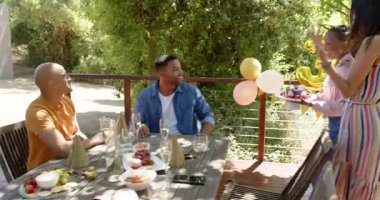 Güneşli bir günde bahçede bir doğum günü partisinde selfie çeken bir grup mutlu, çok ırklı ve siyah erkek ve kadın arkadaş. Kutlama, doğum günü, parti, yaz ve arkadaşlık kavramı.