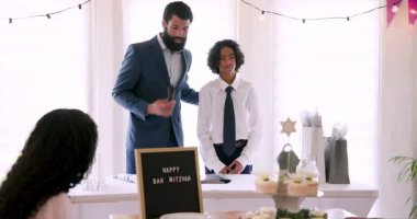 Çeşitli aileler geleneksel tören hazırlıyor ve evde dekorasyonlar ve masada yemekle konuşuyorlar. Bar mitzvah, bat mitzvah, aile, ebeveynlik ve kutlama konsepti.