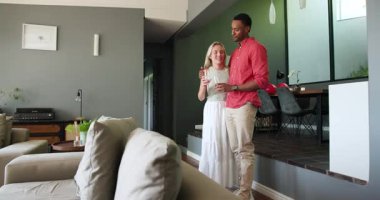 Mutlu siyah adam ve beyaz bayan partneri gülümsüyor, şampanya içiyor ve ev partisinde birbirlerine sarılıyorlar. Eğlence, eğlence, aşk, mutluluk, yaşam tarzı ve ilişki konsepti.