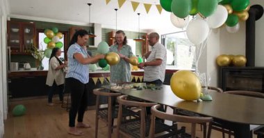 Mutlu kıdemli arkadaşlar konuşuyor, balonları şişiriyor ve parti için evi dekore ediyor. Hazırlık, kutlama, birliktelik, kıdemli yaşam tarzı ve arkadaşlık kavramı.