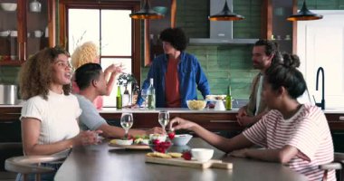 Mutlu çeşitli arkadaşlar gruplar halinde konuşuyor, şarap içiyor ve evde yemek hazırlıyorlar. Kutlama, parti, birliktelik, yaşam tarzı ve arkadaşlık kavramı.