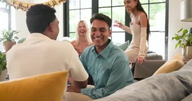 Bir grup mutlu, çok ırklı, beyaz ve Hintli erkek ve kadın arkadaş güneşli oturma odasındaki bir doğum günü partisinde hediye veriyorlar. Kutlama, doğum günü, parti, yaz ve arkadaşlık kavramı.