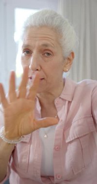 Kafkasyalı mutlu bir kadının videosunun dikey videosu. Yavaş çekim. Ev hayatı, emeklilik, teknoloji ve yaşam tarzı, değişmedi..