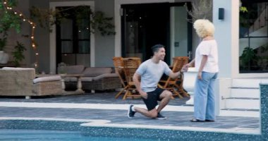 Mutlu adam diz çöküp heyecanlı eşe nişan yüzüğü takıp terasta sarılmayı teklif ediyor. Sürpriz, romantizm, ilişki, ilişki, yaşam tarzı ve evlilik kavramı.