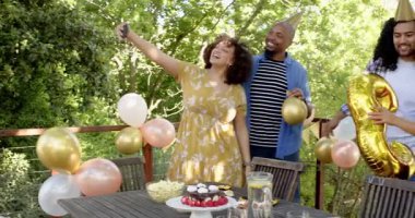 Bir grup mutlu, çok ırklı, siyah ve Çinli erkek ve kadın arkadaş terastaki bir doğum günü partisinde selfie çekiyorlar. Kutlama, doğum günü, parti, yaz ve arkadaşlık kavramı.