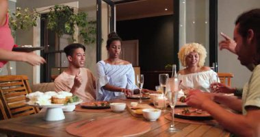 Kutlama partisinden sonra masadan tabakları alan mutlu çift ve arkadaşlar. Kutlama, akşam yemeği, yaşam tarzı ve arkadaşlık konsepti..