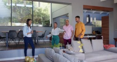 Bir grup mutlu çok ırklı ve siyah erkek ve kadın arkadaş oturma odasında bir doğum günü partisi için dekorasyon hazırlıyorlar. Kutlama, doğum günü, parti, yaz ve arkadaşlık kavramı.