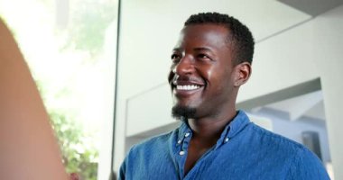 Mutlu çok ırklı ve Afro-Amerikalı çift oturma odasında yüzük takıp evlenme teklif ediyorlar. Kutlama, nişan, parti ve yaşam tarzı konsepti.