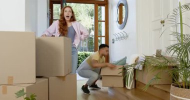 Mutlu adam ve partneri yeni bir eve taşınıyorlar, kutuları, yeni evleri, ev sahiplerini, ipotekleri taşıyorlar. Yeni başlangıçlar, aile hayatı, mutluluk, yaşam tarzı ve ilişki kavramı.