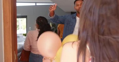 Bir grup mutlu çok ırklı ve siyahi erkek ve kadın arkadaş bir partide selamlaşıp hediyeler veriyorlar. Kutlama, parti, yaz ve arkadaşlık konsepti.