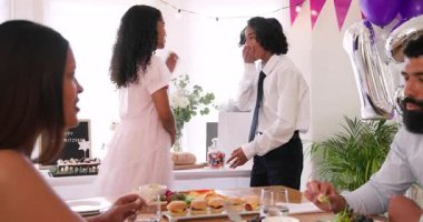 Çeşitli aileler geleneksel törenleri kutluyor, masada oturuyor, yemek yiyor ve evde sarılıyorlar. Bar mitzvah, bat mitzvah, Aile, ebeveynlik, gelenek ve kutlama konsepti.