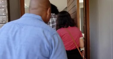 Bir grup mutlu, çok ırklı, siyah ve Çinli erkek ve kadın arkadaş eve girdiler, bir hoşgeldin partisinde selamlaşıp kucaklaştılar. Kutlama, parti, yaz ve arkadaşlık konsepti.