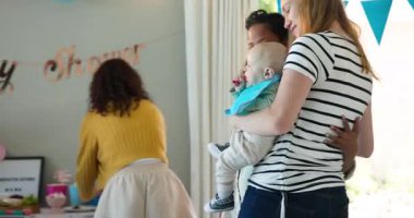 Bir grup mutlu, çok ırklı ve beyaz, bebek kucaklayan ve güneşli oturma odasındaki bir bebek partisinde konuşan bayan arkadaş. Kutlama, annelik, parti, yaz ve arkadaşlık kavramı.