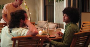 Kutlama yemeğinden sonra tabakları toplayıp sofrayı toplayan mutlu arkadaşlar. Kutlama, akşam yemeği, yaşam tarzı, birliktelik ve arkadaşlık konsepti..