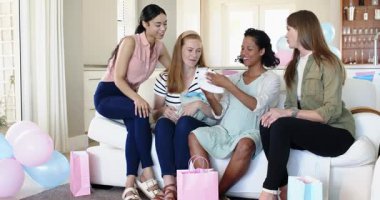 Bir grup mutlu çok ırklı ve bebekle birlikte beyaz bayan arkadaş güneşli oturma odasındaki bebek partisinde hediye veriyorlar. Kutlama, annelik, parti, yaz ve arkadaşlık kavramı.