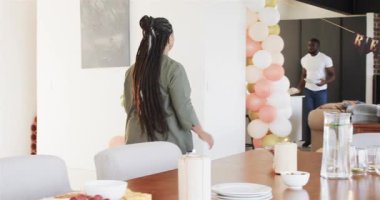 Mutlu siyah çift ve yaşlı aileler oturma odasındaki emeklilik partisinde masayı hazırlıyorlar. Kutlama, emeklilik, parti, son sınıf yaşam tarzı ve aile kavramı.