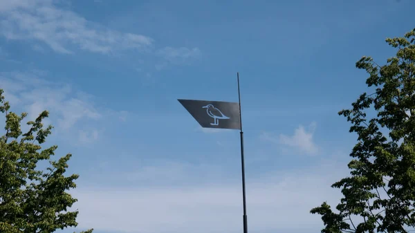 An iron flag flutters in the wind.