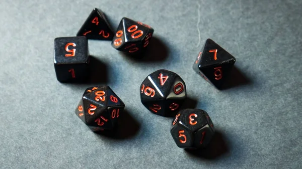 A twenty-sided dice thrown onto a white surface.