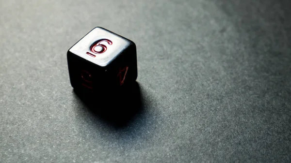 A twenty-sided dice thrown onto a white surface.