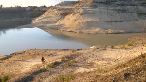 Ein großer sandiger Hügel und ein kleiner See darunter. — Stockvideo