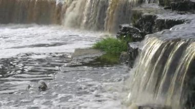 Şelale, nehirden akan su. Kahverengi renkli, fırtınalı bir nehir..