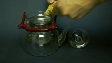 Çay seremonisi, çay demleme. Bir adam çaydanlığa çay ve ot koyar ve kaynar su döker..