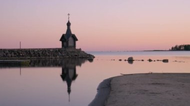 Güzel mavi bir gökyüzüne karşı sahilde duran kilise. Taş kıyısı. Şapel kıyıda bir deniz feneri gibi görünüyor..