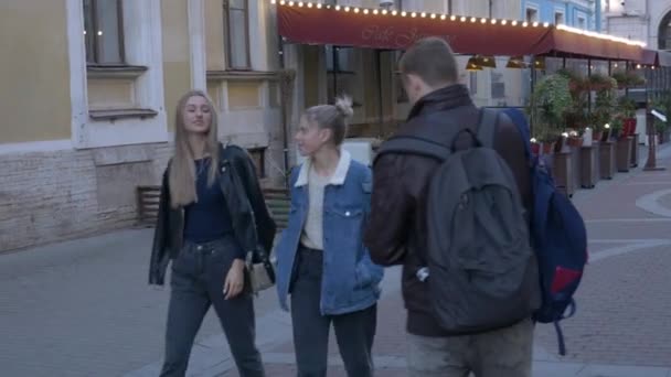 男性のビデオグラファーは 街を歩く2人の女性モデルを撮影します 仕事中のビデオだ 街中で女の子を撃つ — ストック動画
