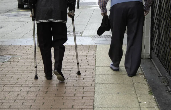 Older gentlemen with walking stick and crutches, health