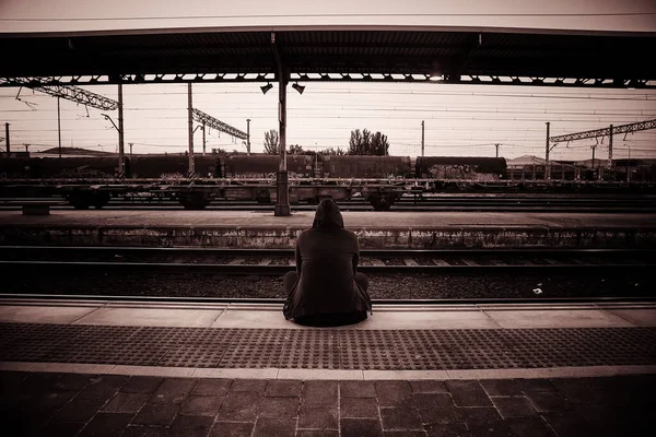Young woman on the train tracks, transport detail, loneliness and melancholy
