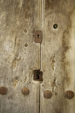 Ahşap kapıdaki eski metal kilit, güvenlik detayları.