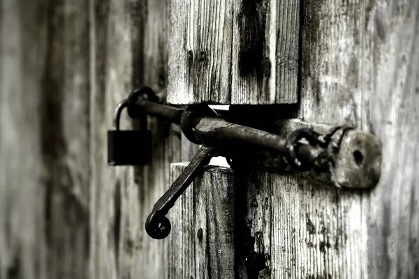 Eski terk edilmiş ahşap kapı, güvenlik detayları ve harabe.