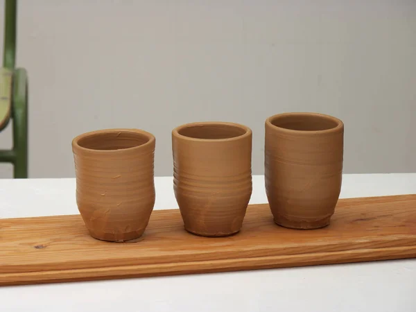 Clay glasses drying in the sun, three clay glasses, three objects