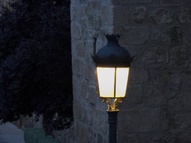 Sokak lambası gün batımında yaktı. Şehirde gün batımında yeni aydınlatılmış lamba