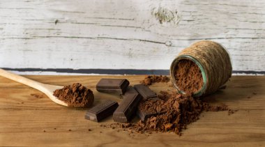 Çikolata ve saf kakao tozu, eski bir ahşap zemin üzerine ons