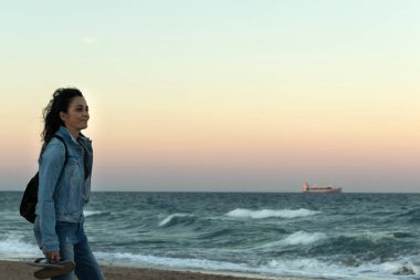 Valencia, İspanya bir plajda gün batımını izlemek ve kadın ile kot denim ceket,