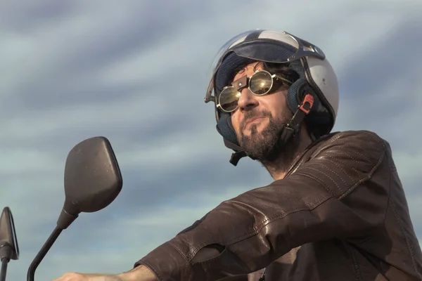 Bir motosiklet üzerinde kahverengi deri ceket ile esmer adam — Stok fotoğraf