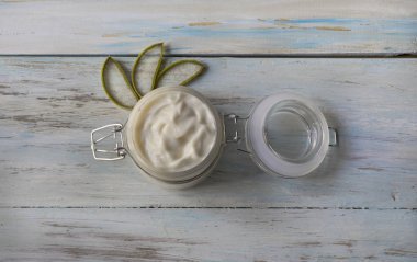 Bir cam kavanozda ev yapımı Aloe Vera krem, açık ahşap arka planda kesilmiş Aloe yaprakları ile