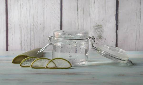 Cam kavanozda doğal Aloe vera jeli, açık ahşap arka planda. Önden görünüm